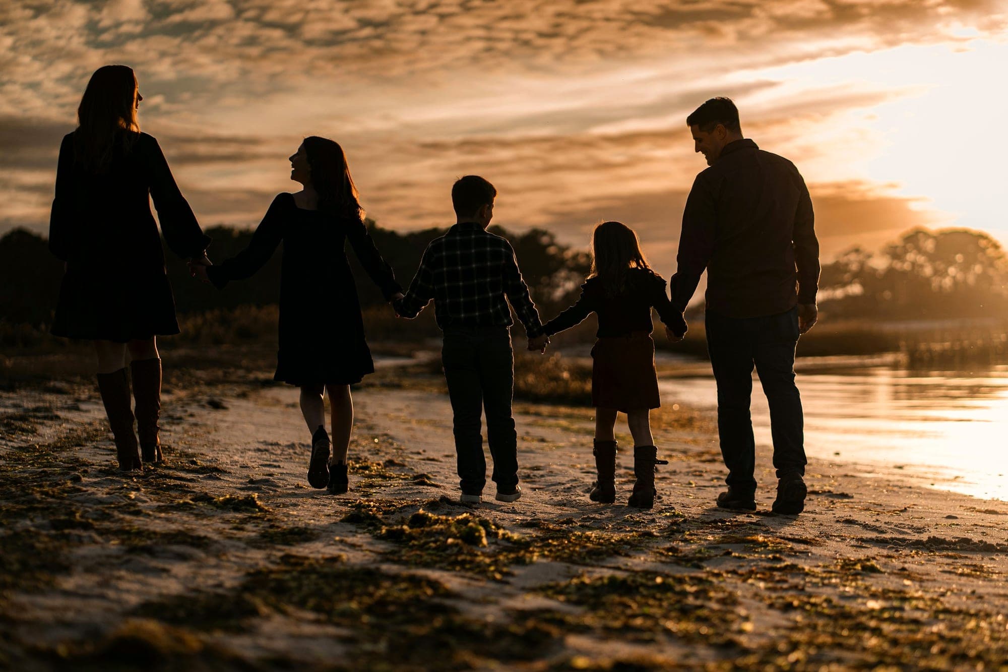 A family strolling together on the beach at sunset