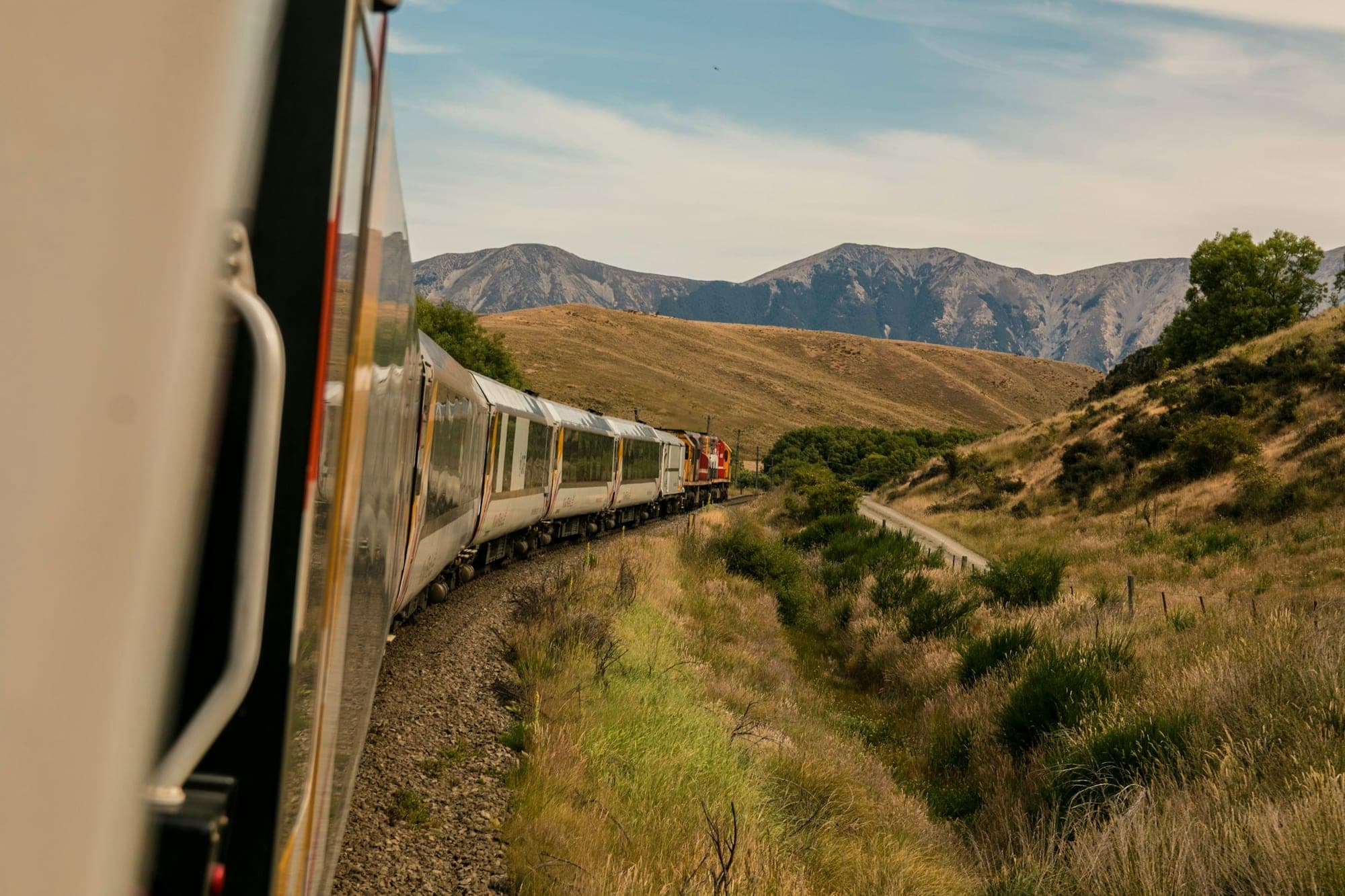 A scenic train running alongside a distant mountain range