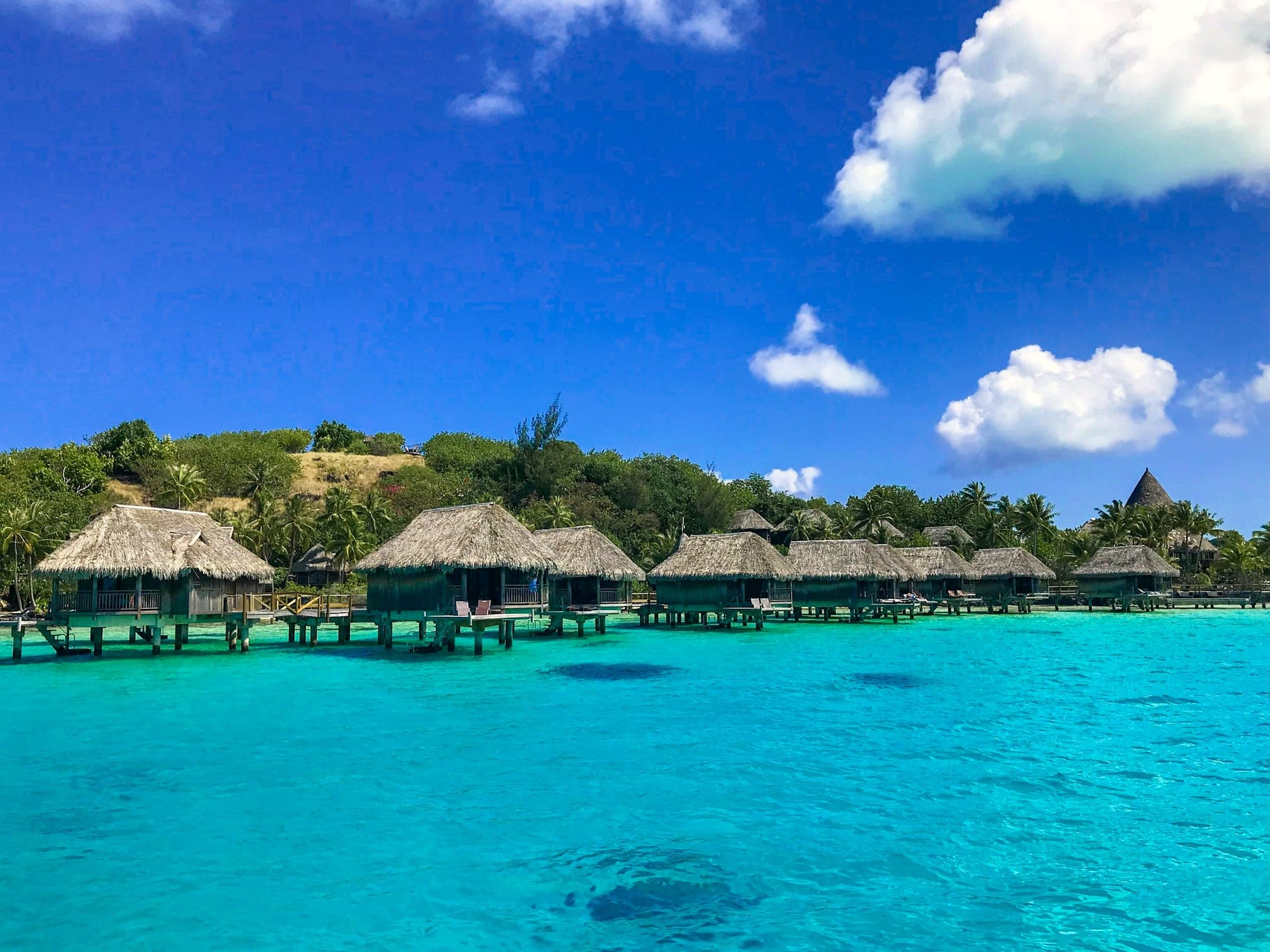 Overwater bungalows above a vivid South Pacific lagoon